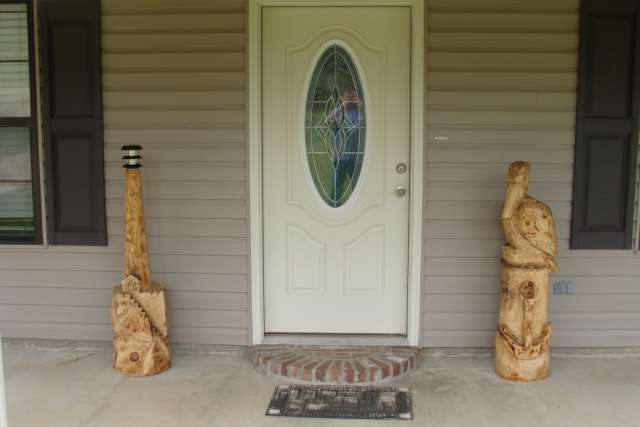 A front door with two wooden sculptures in front of it.