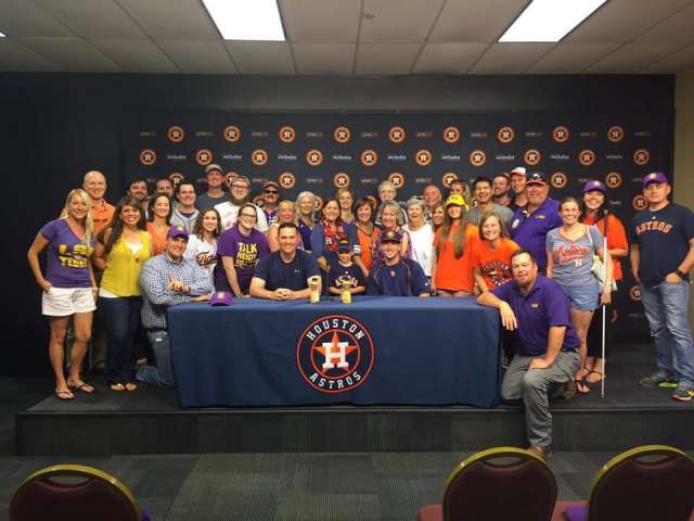 The houston astros team posing for a picture in front of a table.